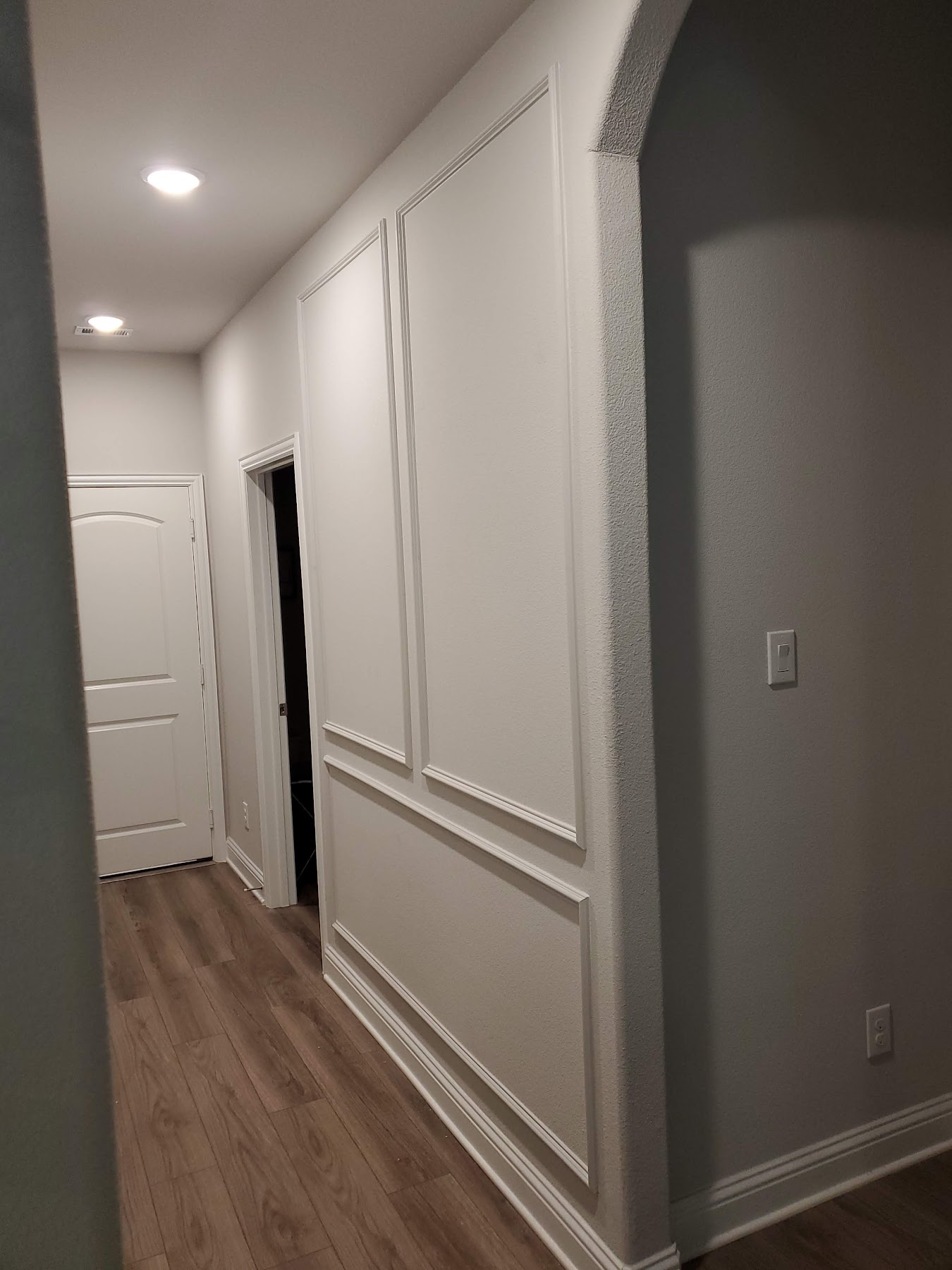 Finished hallway detail with wall paneling and flooring