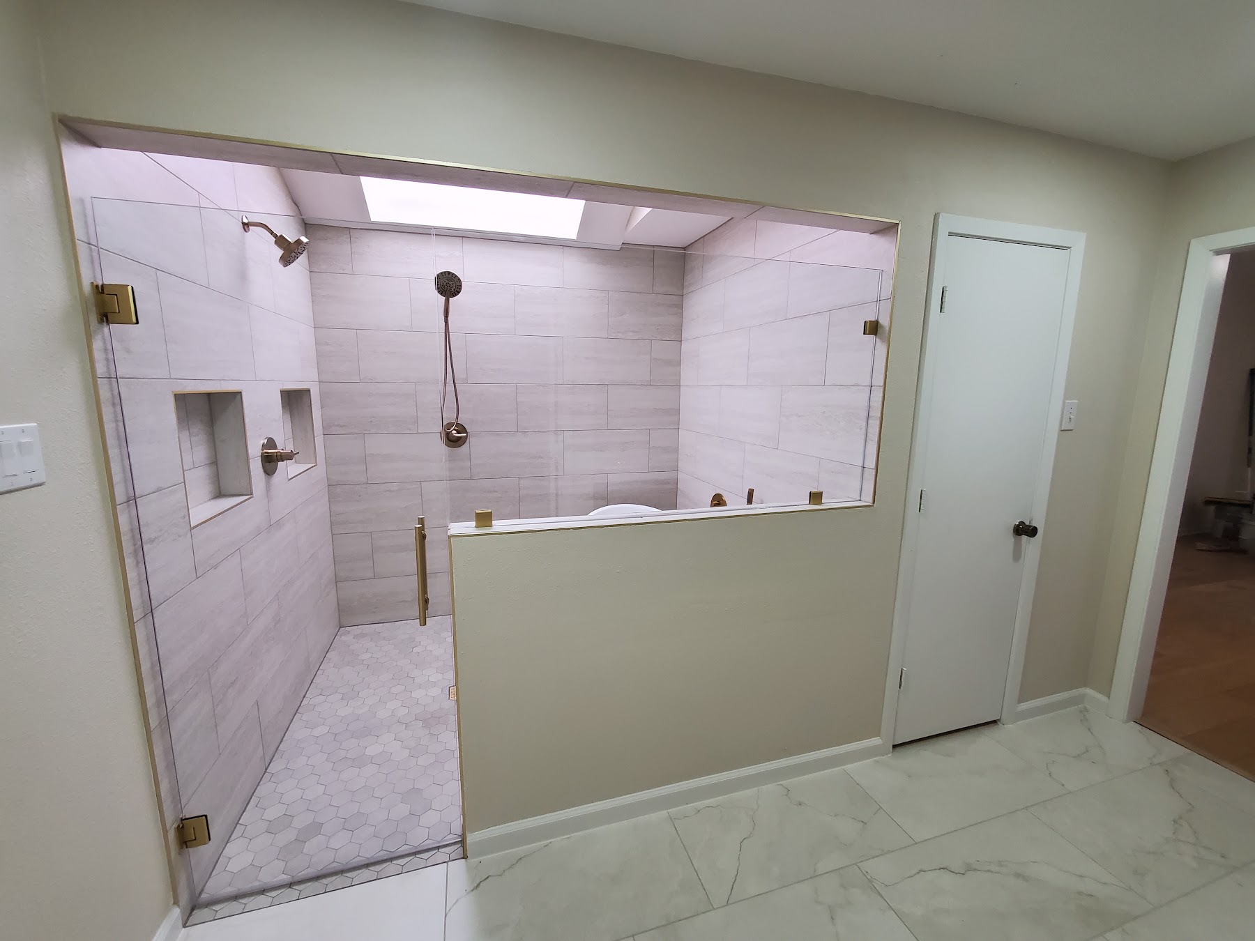 Completed walk-in shower renovation with glass enclosure and tile