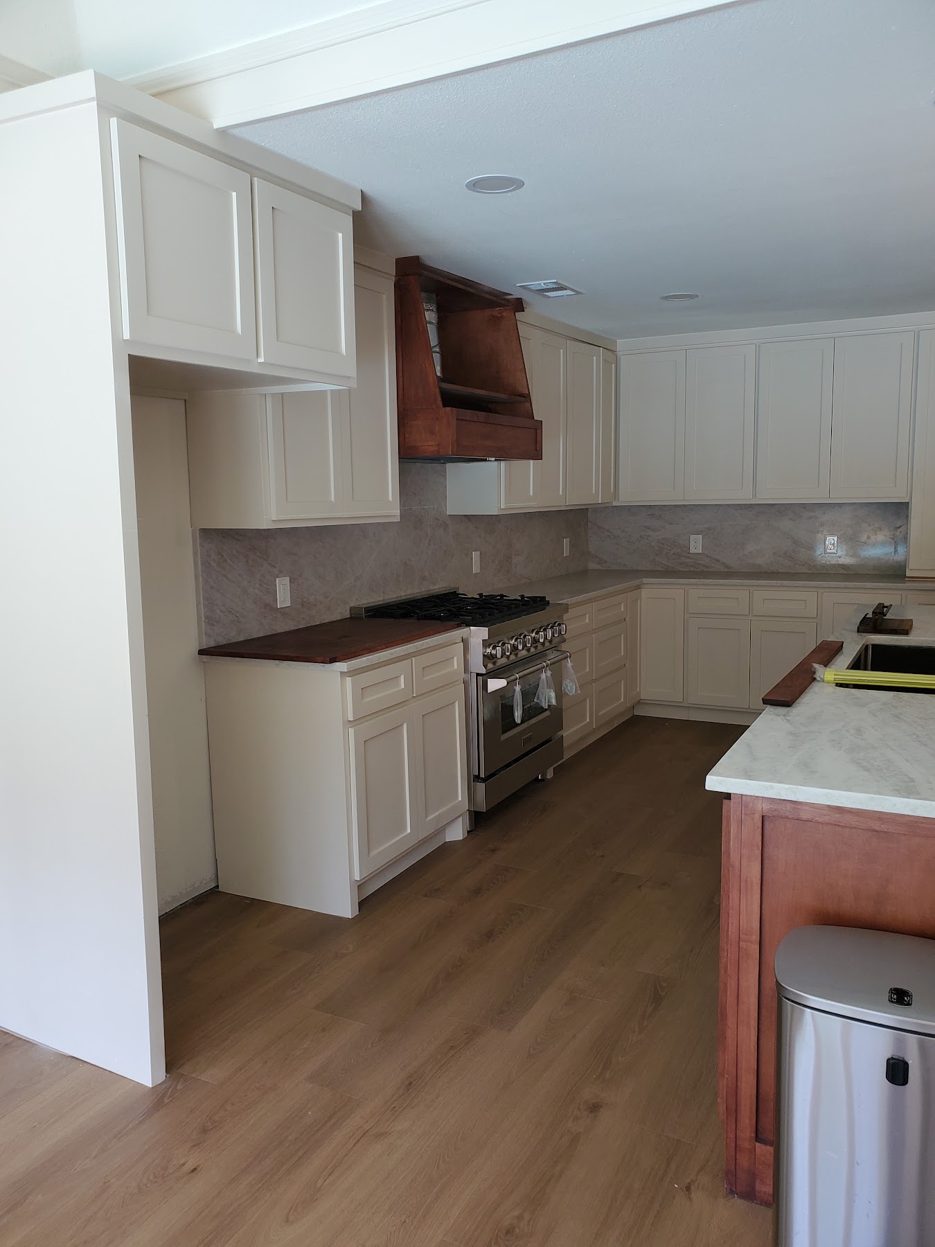 Wide view of completed white kitchen cabinetry and island